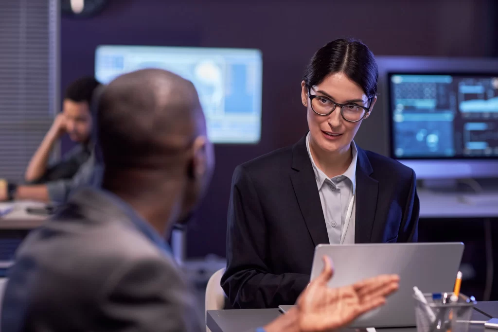 Serious Businesswoman Using Laptop During Meeting