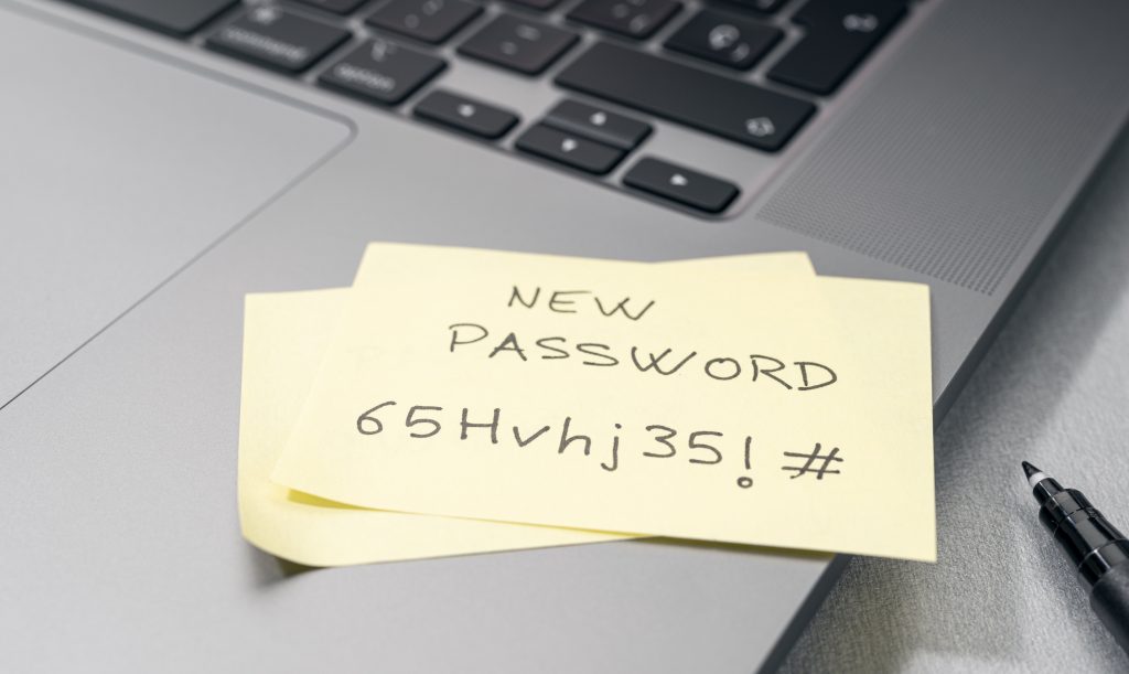 Change of password to a stronger one message on sticky note on laptop. computer security management concept