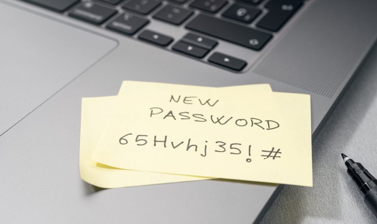 Change of password to a stronger one message on sticky note on laptop. computer security management concept